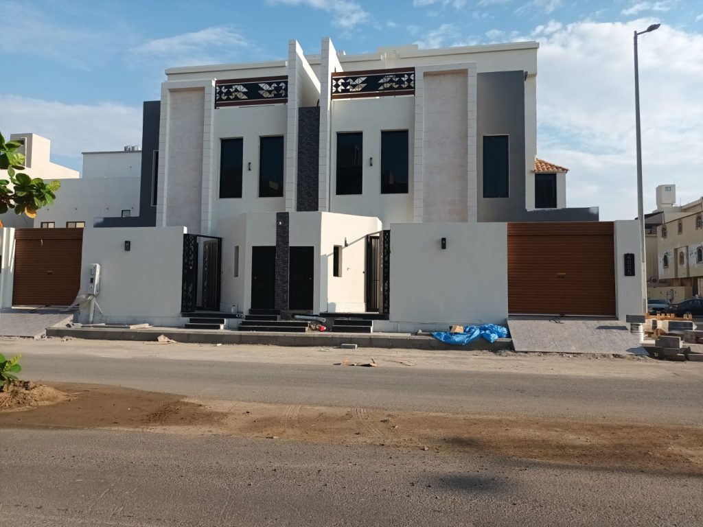 واجهة فيلا سكنية منتهية التشطيب بتكسية حجرية وعناصر معدنية مزخرفة وبوابات خشبية